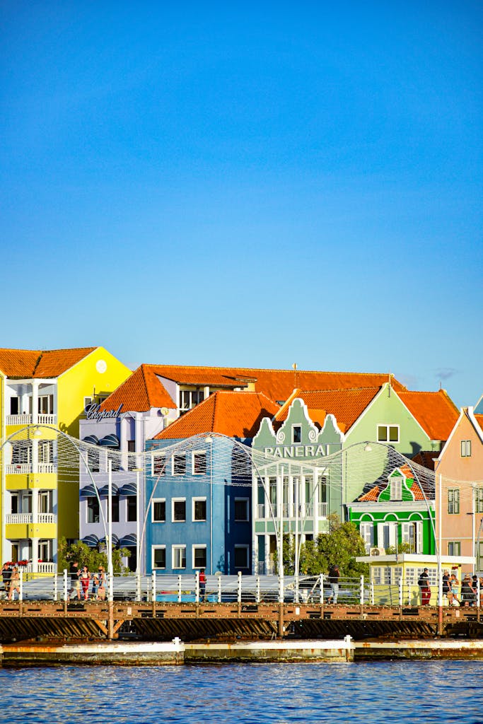 Vibrant buildings along the waterfront in Willemstad, Curaçao under a clear blue sky.